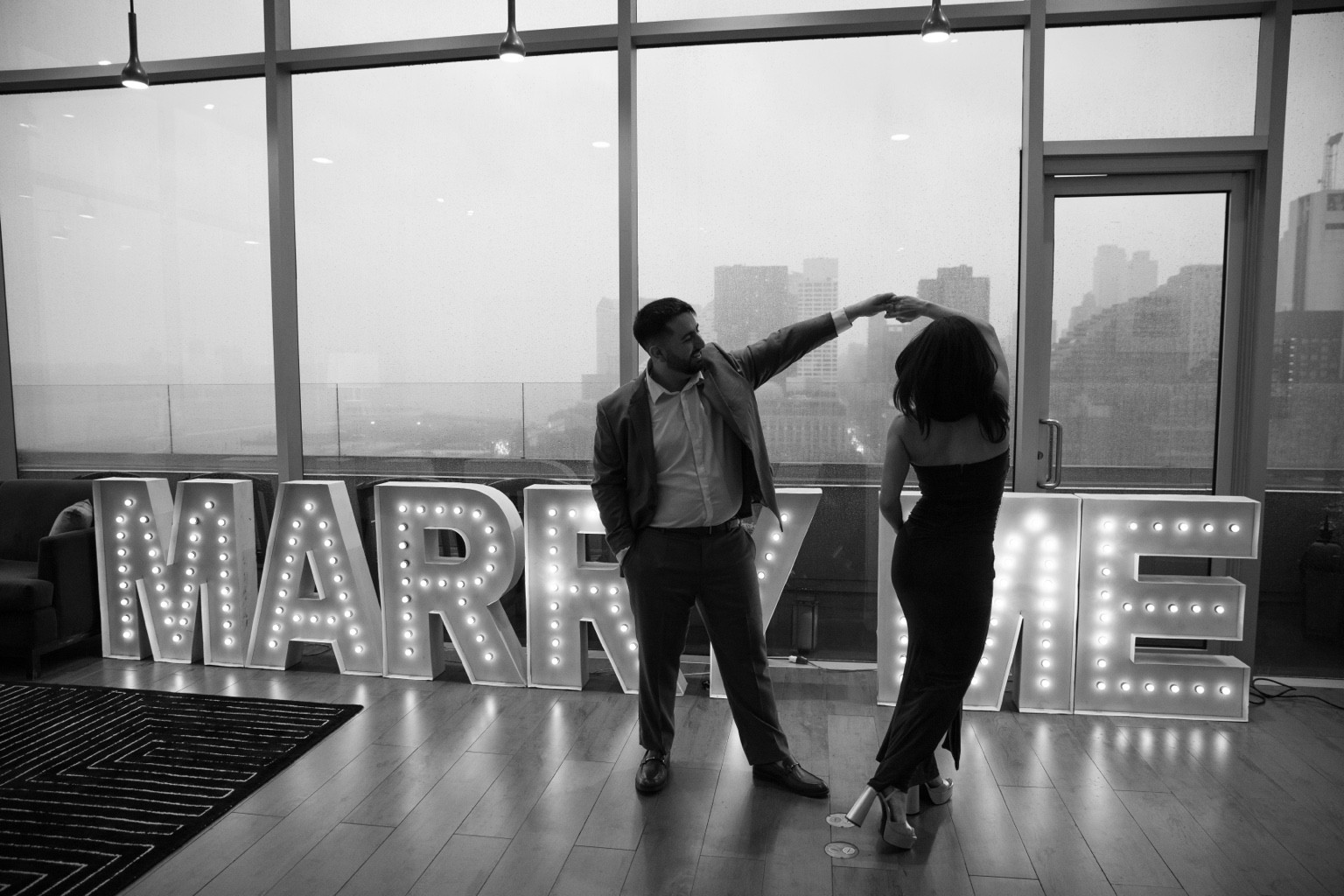 Ingrid and Connor dancing in front of the Marry Me letters